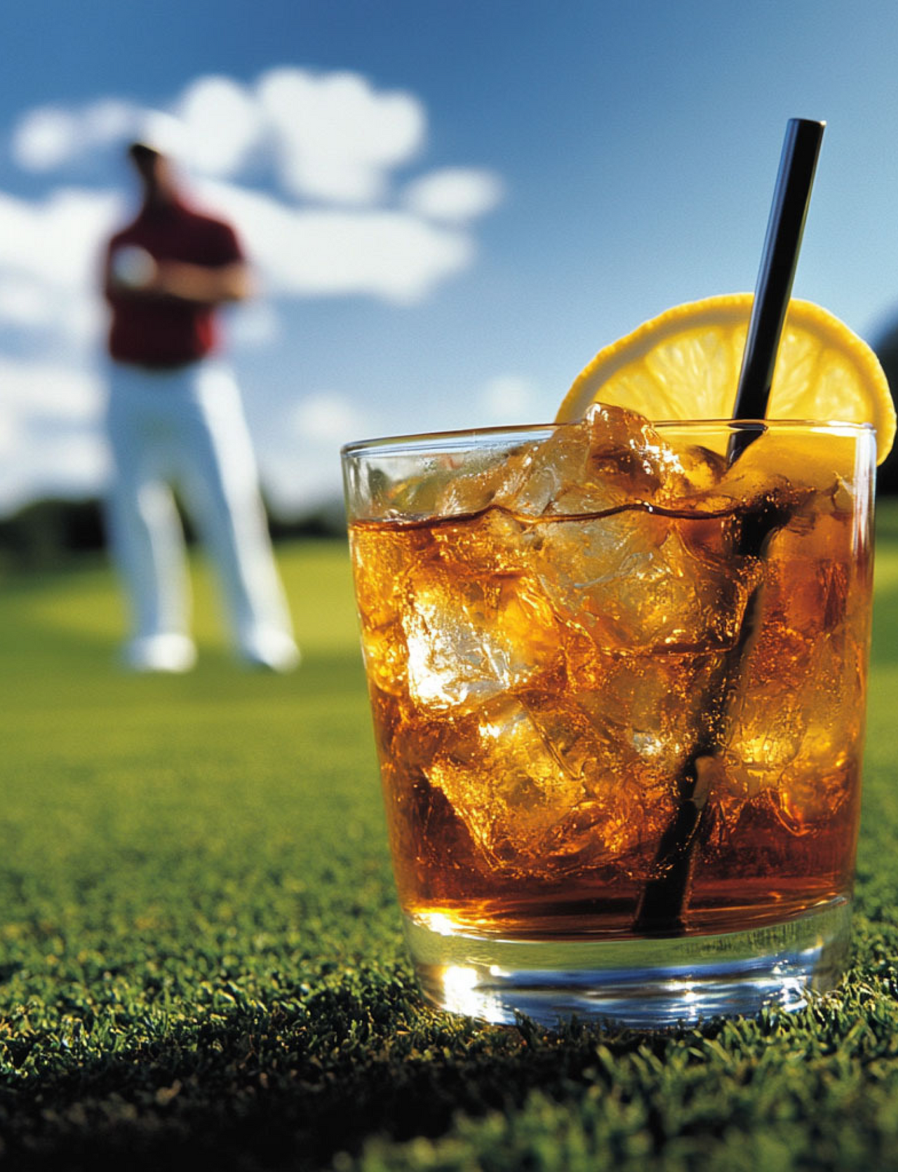 Man on a golf course drinking a Par non-alcoholic cocktail in a lowball glass with lemon